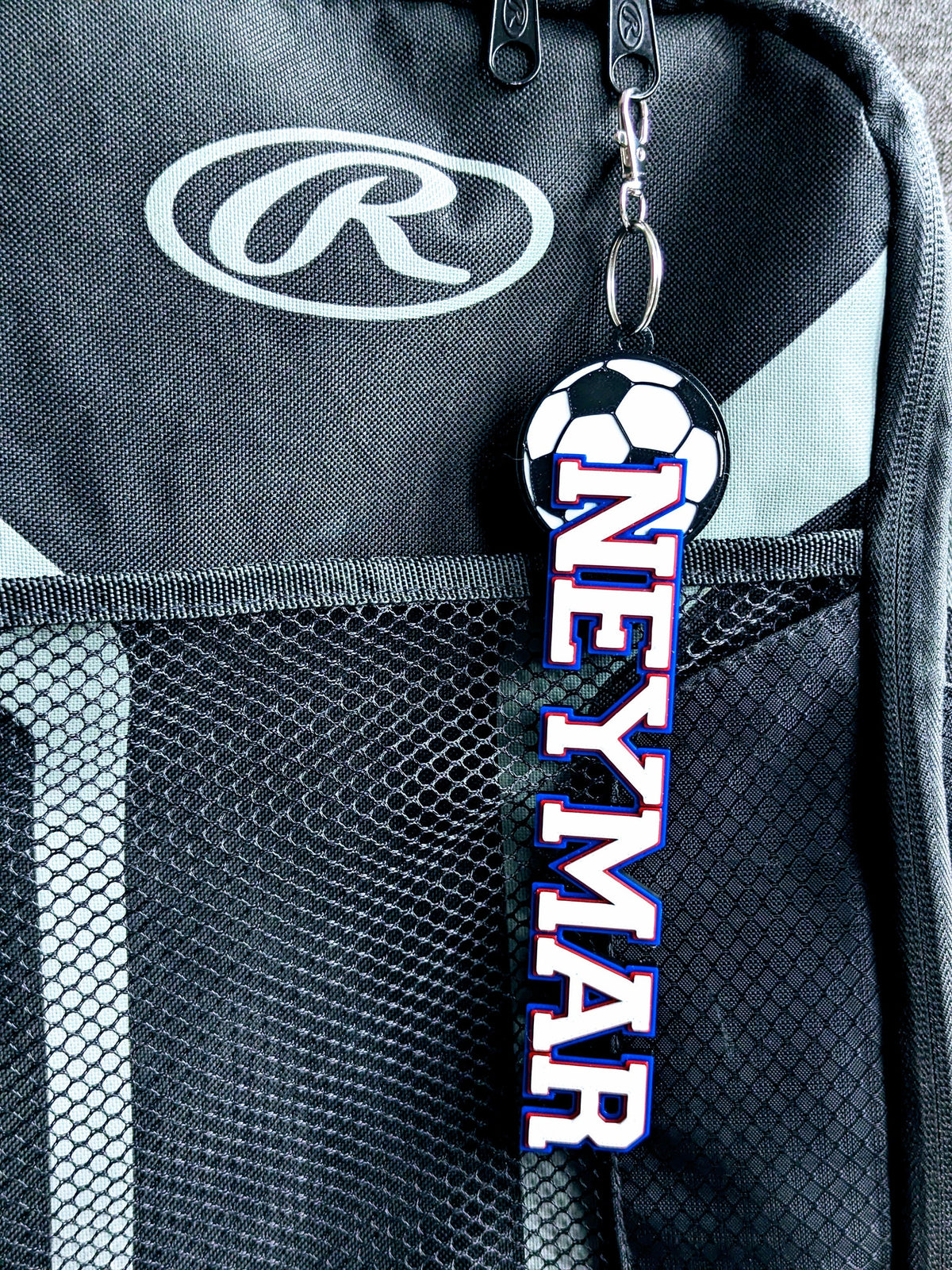 Soccer bag tag "NEYMAR" in red, white and blue on a sports backpack