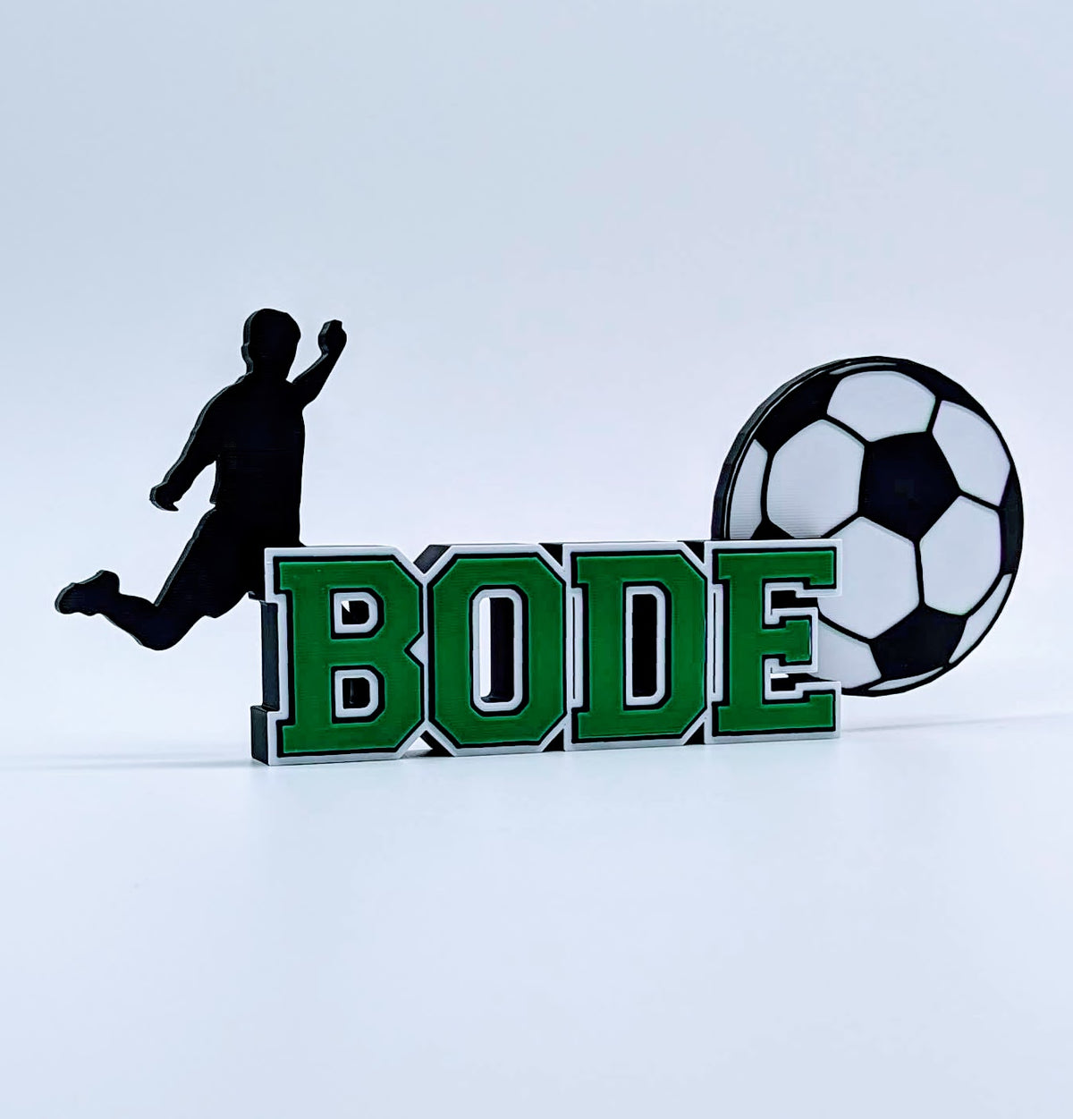 Custom soccer nameplate "BODE" in green, white and black for a young player
