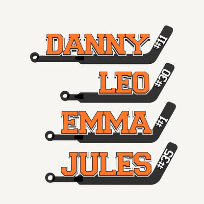 Set of four personalized hockey goalie stick bag tags in orange and black: DANNY #11, LEO #30, EMMA #1 and JULES #35