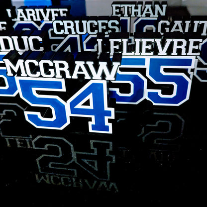 Team set of personalized hockey jersey number nameplates in blue, white and black for a whole hockey team