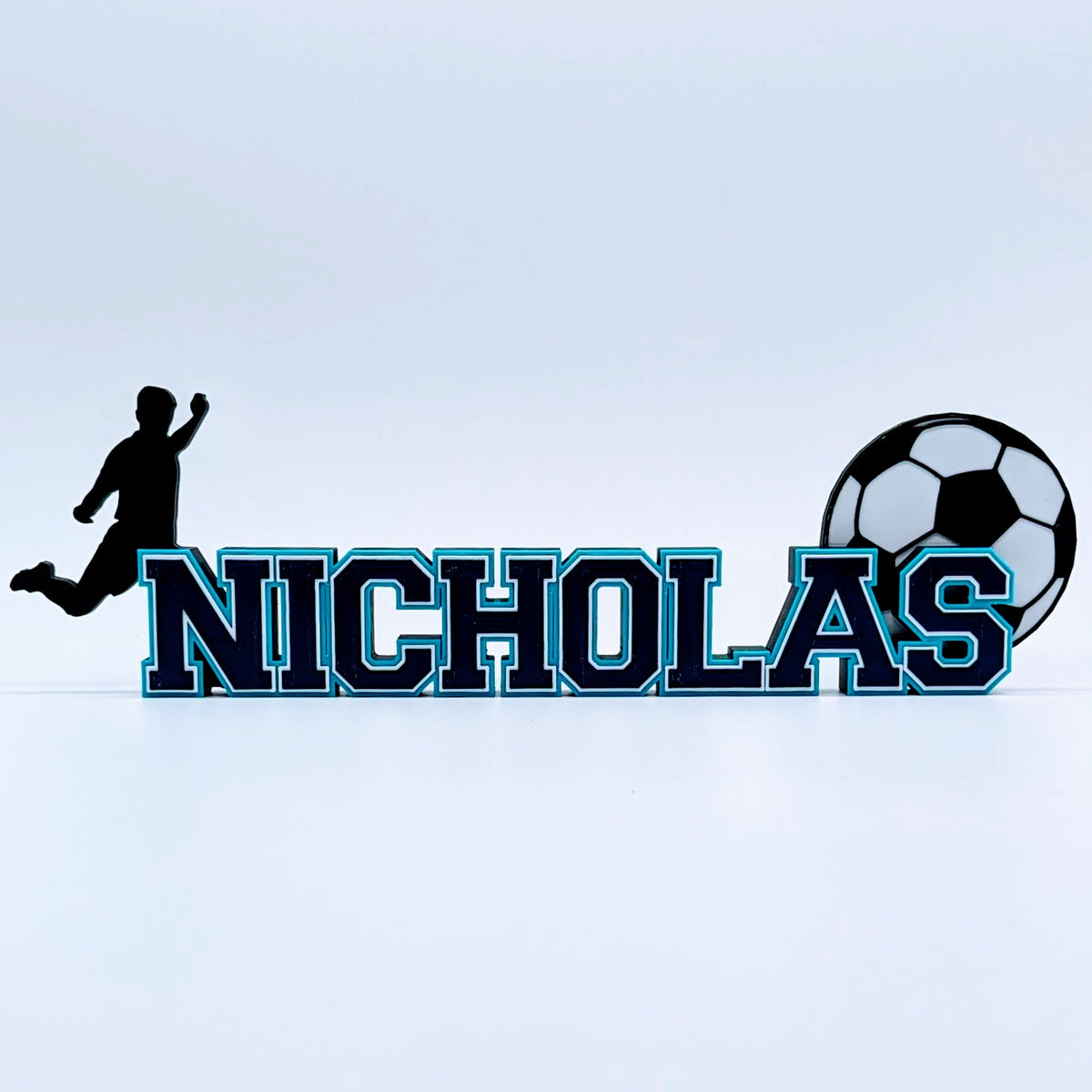 Long soccer name sign "NICHOLAS" in navy and light blue with soccer ball