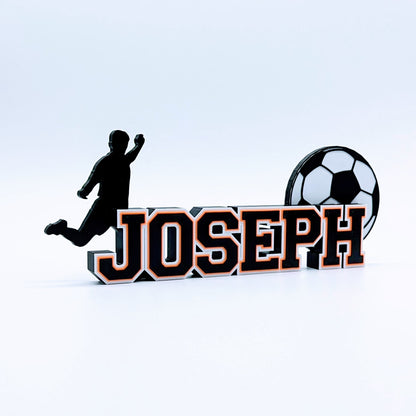 Personalized soccer nameplate "JOSEPH" in black and orange with player silhouette and soccer ball