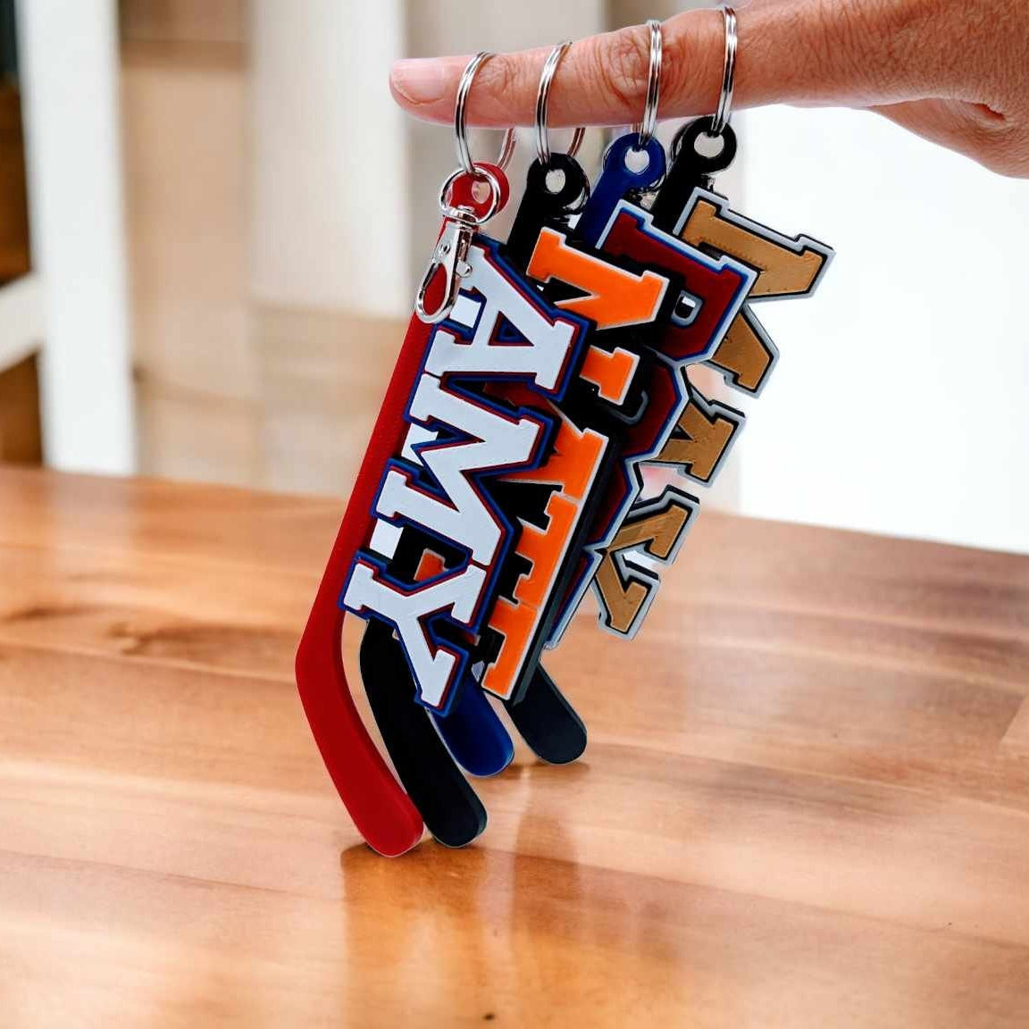 Hockey stick bag tags in team colors hanging from a hand